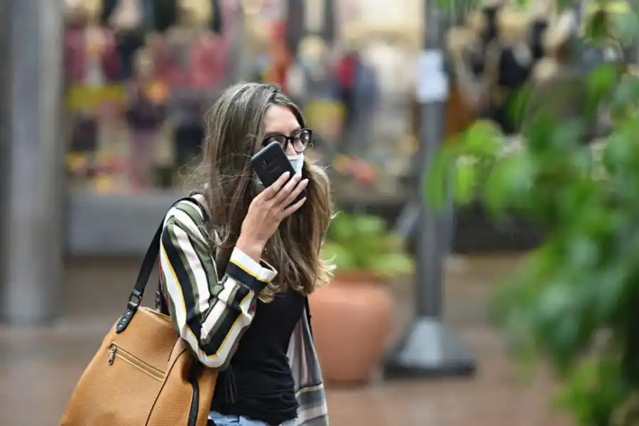 NOTA DE VOZ. El barbijo no fue un impedimento para que esta transeúnte enviara mensajes de audio con su teléfono celular. LA GACETA/ JUAN PABLO SÁNCHEZ NOLI