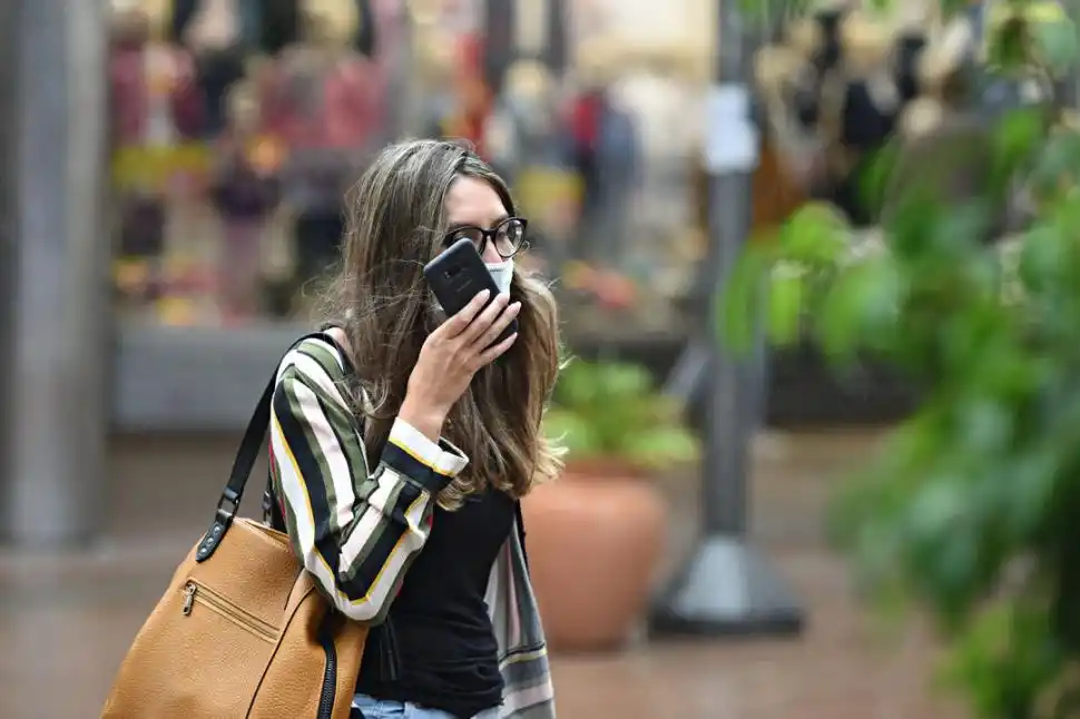 NOTA DE VOZ. El barbijo no fue un impedimento para que esta transeúnte enviara mensajes de audio con su teléfono celular. LA GACETA/ JUAN PABLO SÁNCHEZ NOLI