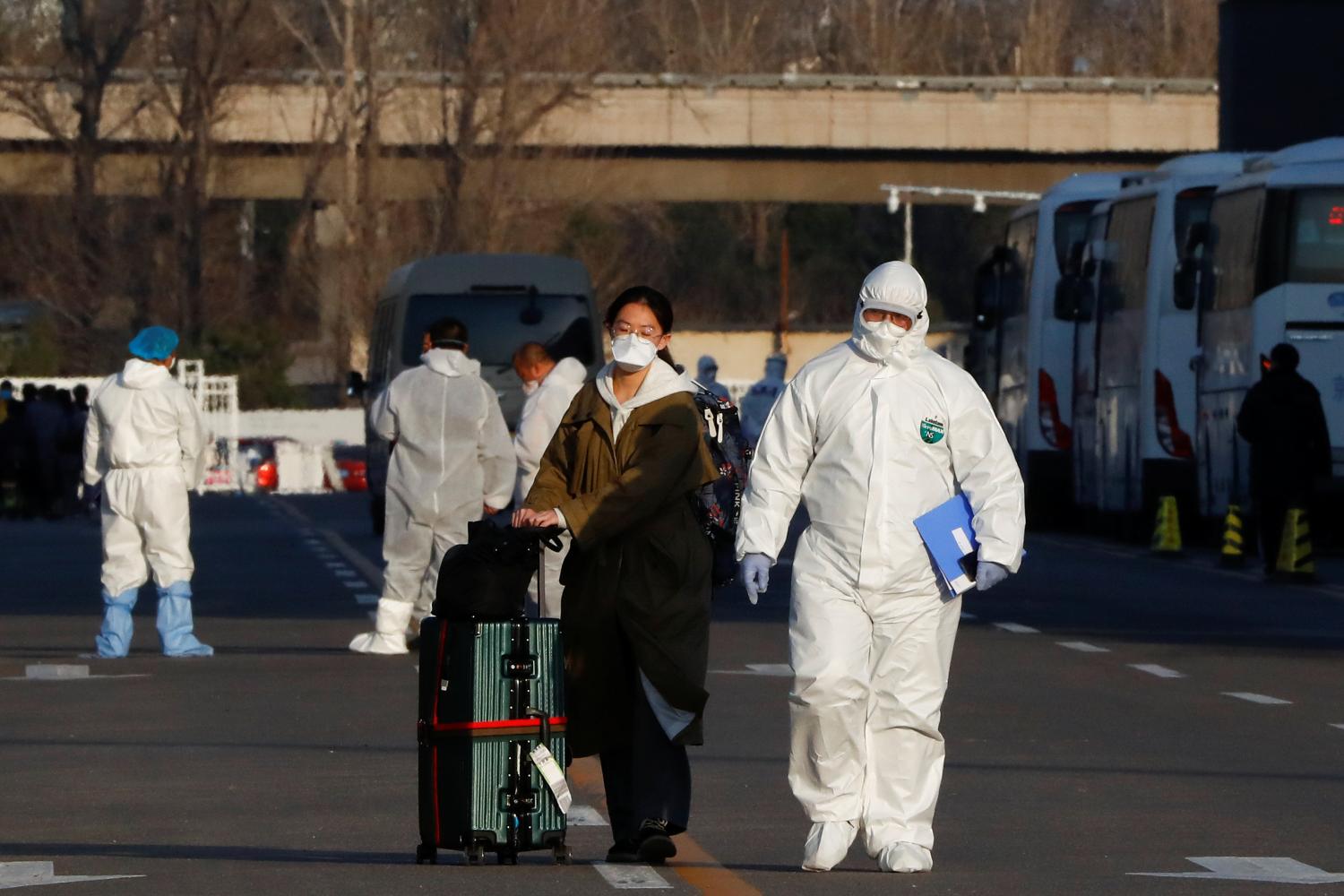 Personal con trajes de protección acompaña a los pasajeros / REUTERS.