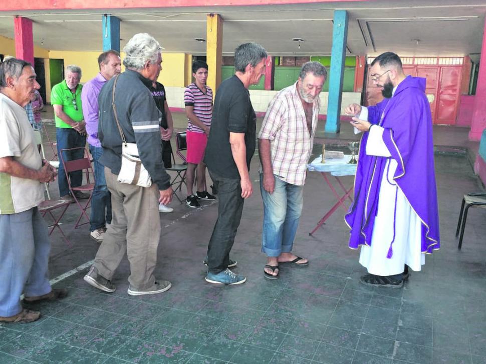 APOYO ESPIRITUAL. El padre Gustavo Pedro ofrece la comunión a los albergados después del oficio de una misa.