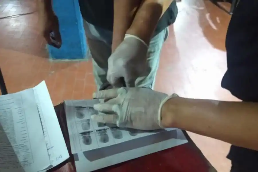 “PIANITO”. Un policía le pinta los dedos a uno de los aprehendidos.  