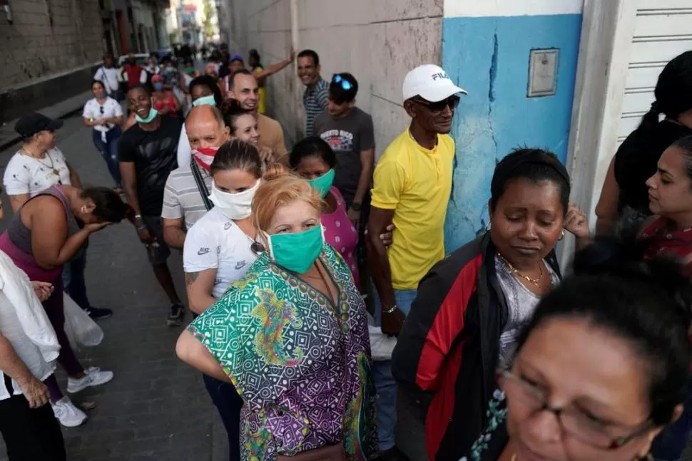 AGLOMERACIÓN. Un grupo de cubanos hace fila afuera de una tienda estatal, en La Habana. reuters