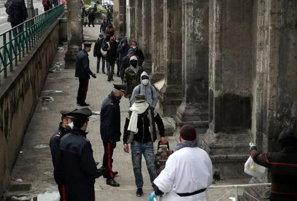 ASISTENCIA. Indigentes de Nápoles hacen fila para buscar comida. Reuters