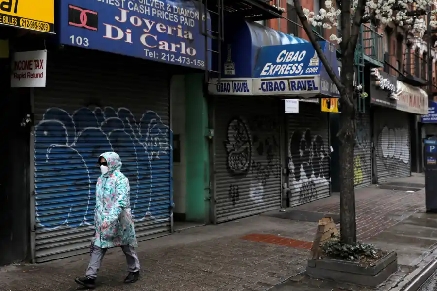 CERRADO. Una mujer camina por la zona sur de Manhattan, que en una jornada de persianas bajas.