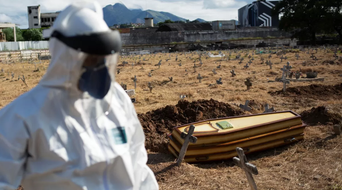 PREVENTIVO. En el cementerio Sao Francisco Xavie, de Río de Janeiro, un hombre usó un traje especial para enterrar a una personas que murió por causas desconocidas, en medio de la pandemia.