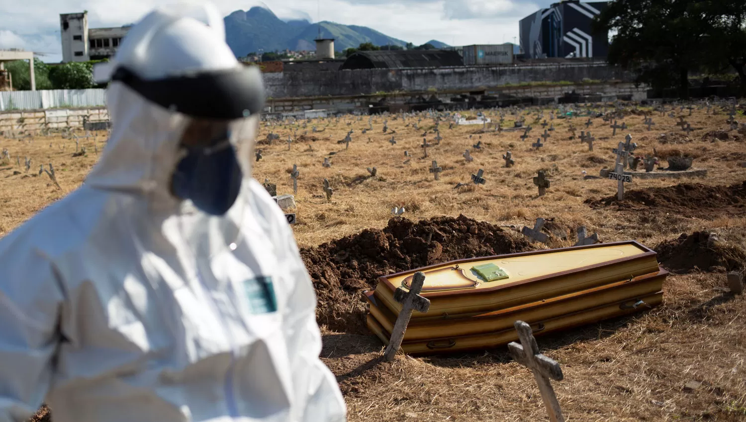 PREVENTIVO. En el cementerio Sao Francisco Xavie, de Río de Janeiro, un hombre usó un traje especial para enterrar a una personas que murió por causas desconocidas, en medio de la pandemia.