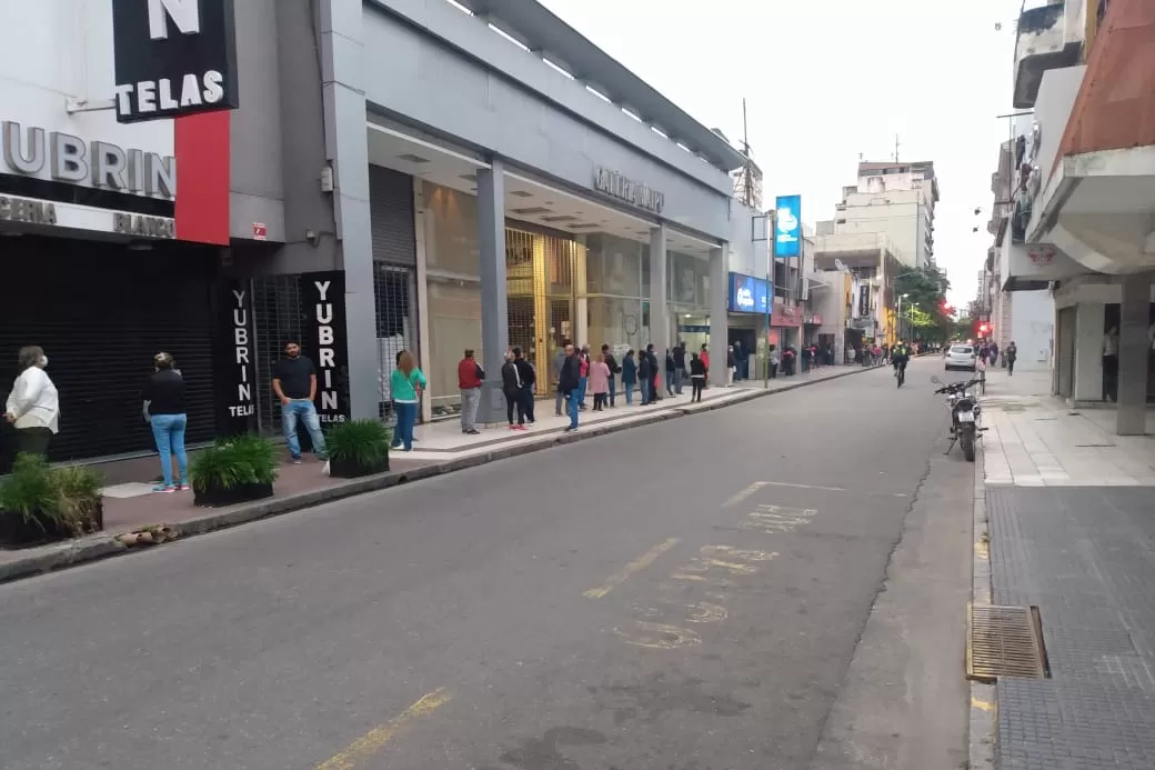 A LA ESPERA. Decenas de personas esperan ser atendidas en los bancos de la city tucumana.
