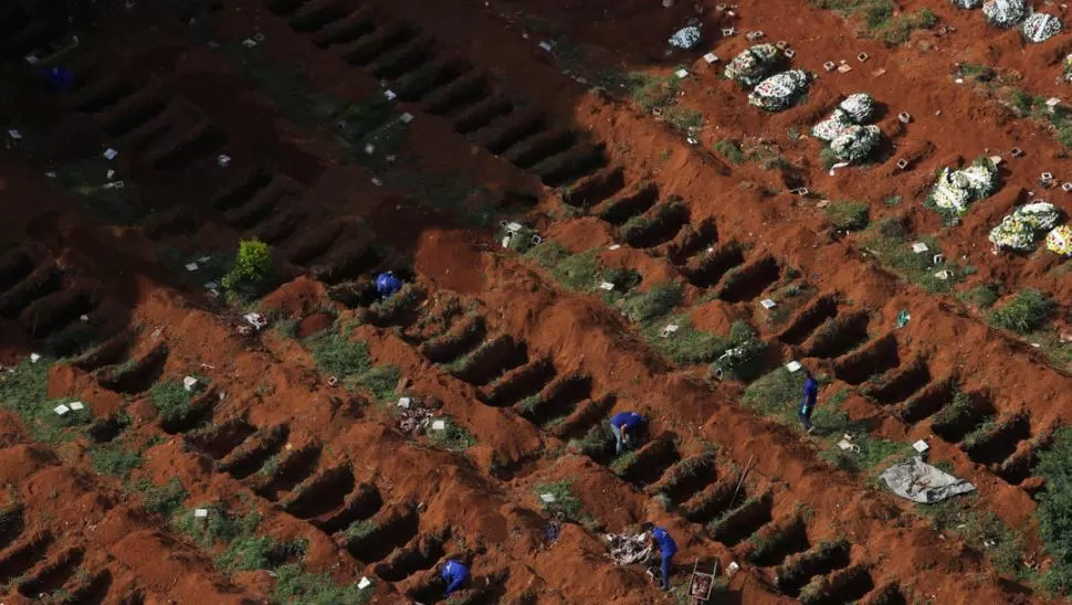 AL RAS DE LA TIERRA. Los enterradores de Vila Formosa abrieron decenas de tumbas, a medida que aumentan los muertos por el coronavirus. reuters