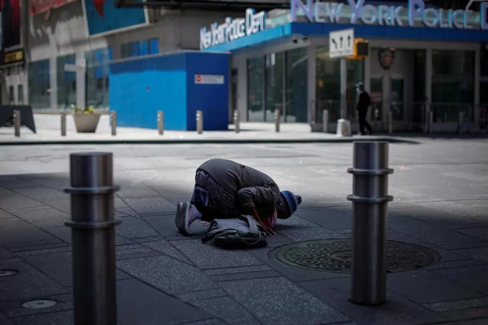 PLEGARIAS. Una mujer musulmana se detiene en la plaza de Times Square casi vacía, en medio de Manhattan, para sus rezos de mitad del día.  reuters