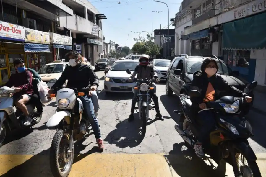 DOS MODOS DE ENFRENTAR EL RIESGO DE VIDA. Todos los motociclistas llevan barbijo, pero sólo uno tiene casco. En Colón y San Martín