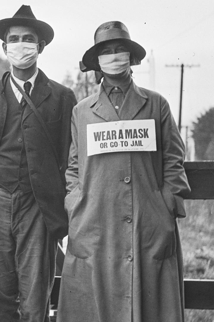 TAPABOCAS O REJAS. En el cartel de la mujer se lee: “Use barbijo o vaya preso”. La imagen pertenece a California, a fines de 1918.  