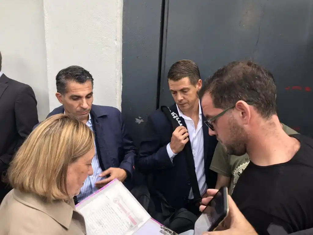 El árbitro Delfino junto a la escribana en la puerta del estadio cerrado.