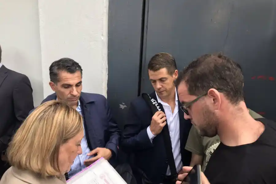 El árbitro Delfino junto a la escribana en la puerta del estadio cerrado.
