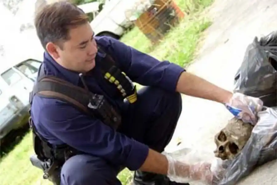 MACABRO. Un efectivo coloca en una bolsa de plástico el cráneo del remisero Carlos Salazar, que estaba desaparecido desde el 1 de enero de 2004.