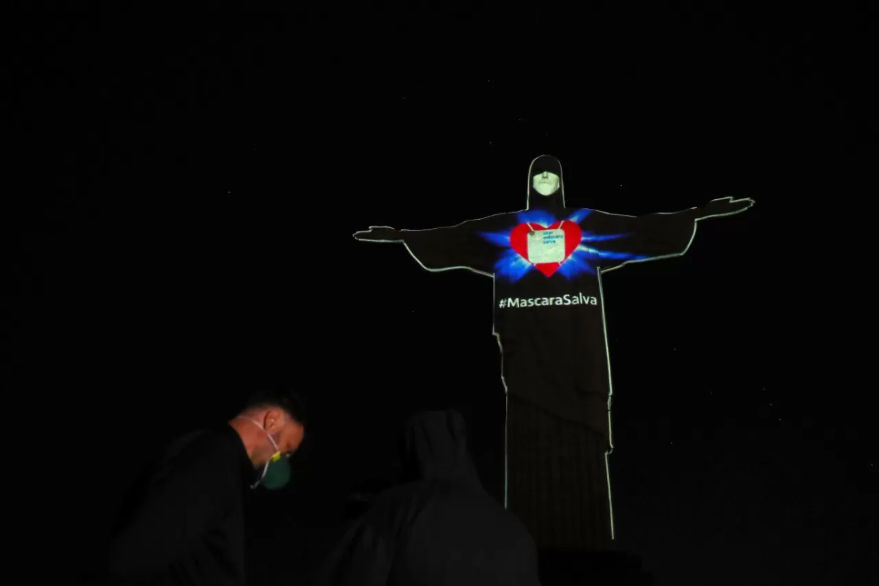 El Cristo Redentor se iluminó con una máscarapara promover el autocuidado. REUTERS