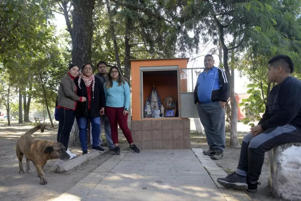 EN LOS POCITOS. La familia de René Amado, en la plaza central del barrio, frente a la gruta de la Virgen que construyó el padre de familia. la gaceta  / foto de franco vera