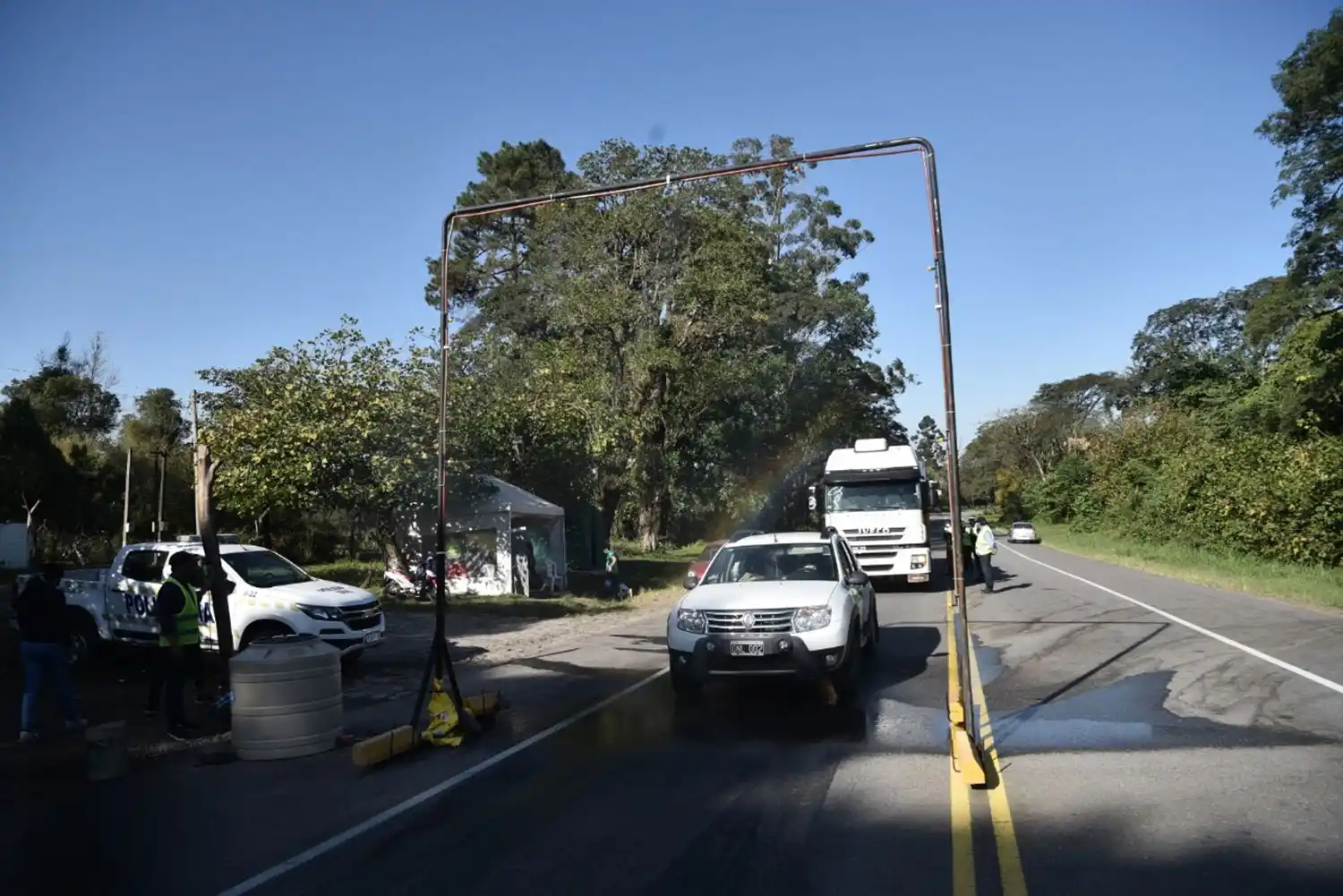 DESINFECCIÓN EN LAS MESADAS. Un vehículo atraviesa el arco montado en el puesto de Santa Lucía. LA GACETA/FOTO DE OSVALDO RIPOLL