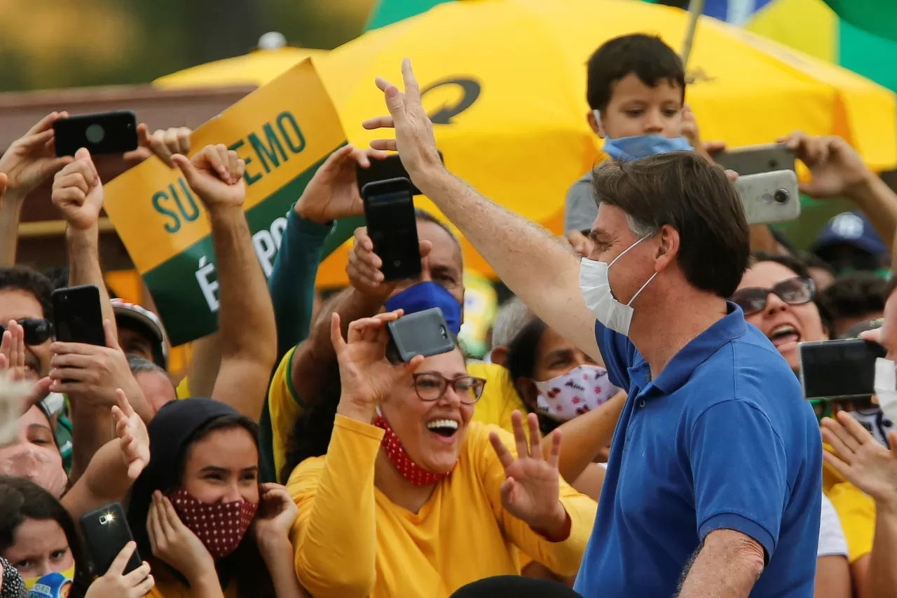 EN LA MANIFESTACIÓN. Bolsonaro, con el barbijo puesto, saluda a los presentes. REUTERS