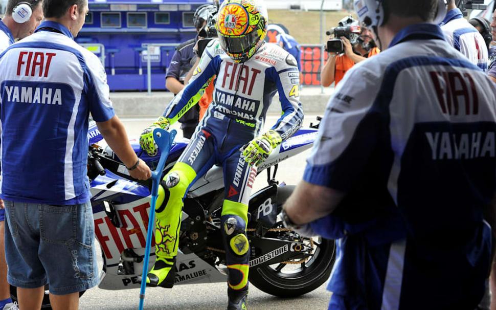 AYUDA. Rossi, por su lesión, era asistido por miembros del equipo y un bastón.