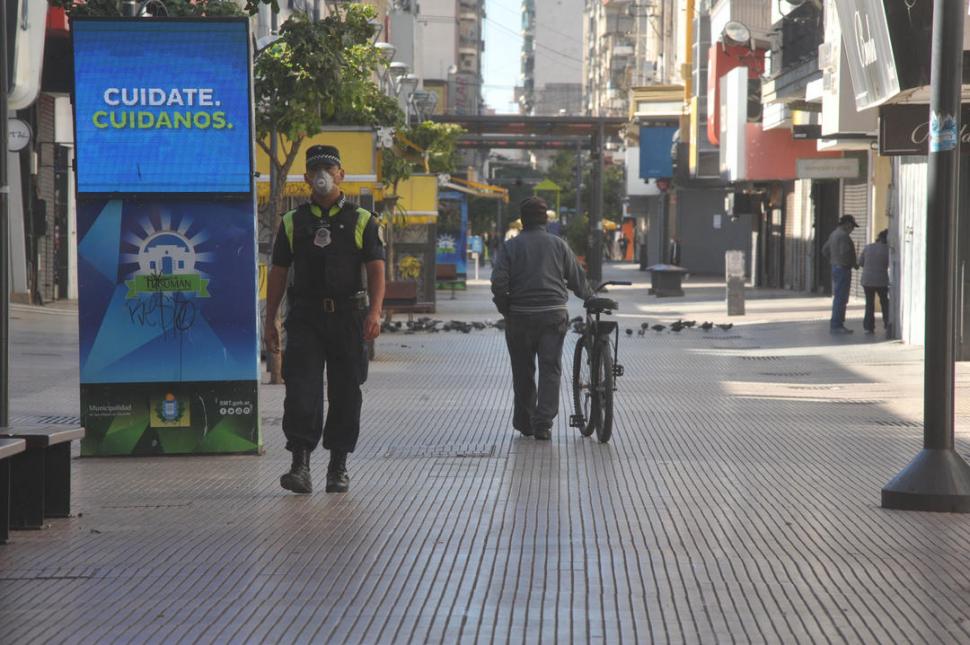  TRANQUILIDAD DEL FERIADO. Las palomas se adueñaron de la peatonal, indiferentes al sereno ciclista, a los curiosos y al policía que vigila.