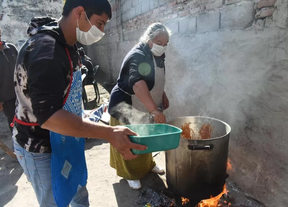 COCINANDO. Daniel López y Mercedes Villagra cocinaron una ollada de guiso de fideos en La Costanera. la gaceta / foto de analia jaramillo 