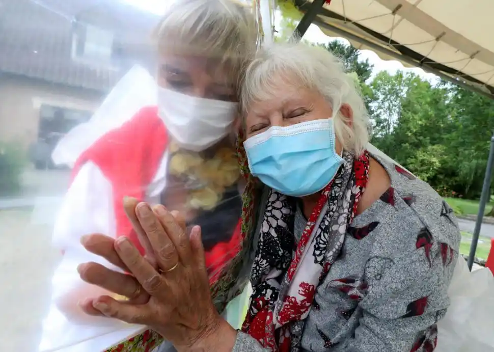 ABRAZOS CUIDADOS. Una residencia para mayores, en Bélgica, ofrece a sus residentes el contacto físico que el coronavirus les niega: a través de una pared plástica.  