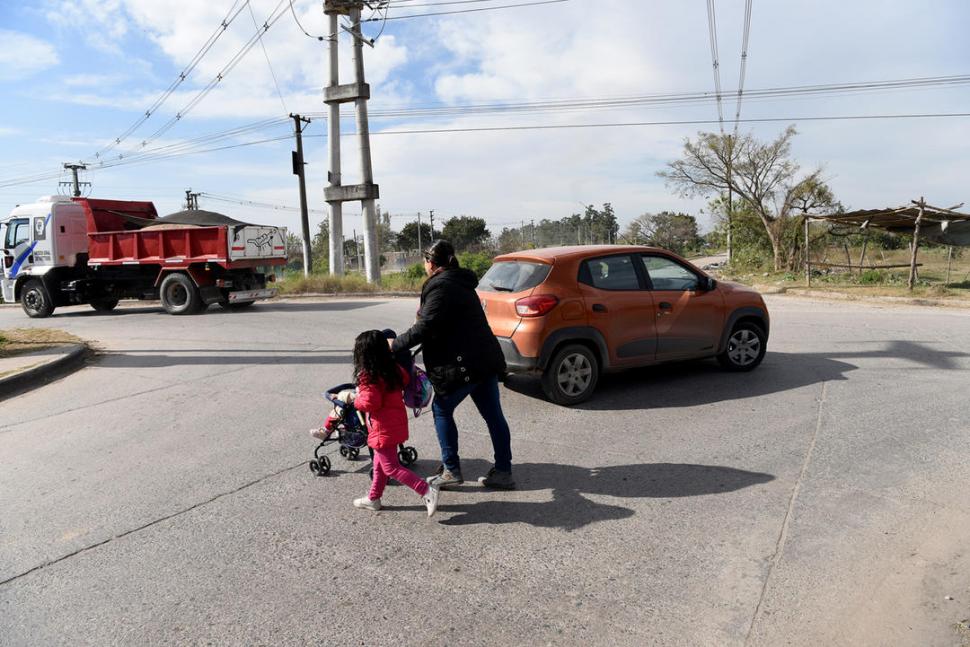 RIESGOS. Una mujer cruza la avenida con sus hijos; el tránsito es intenso debido que a que cada vez hay más barrios en la zona.