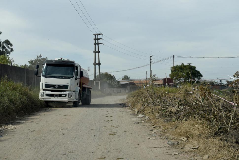 TRÁNSITO PESADO. Un camión avanza sobre un sector de la avenida que no fue pavimentado y que está rodeado por pastizales.