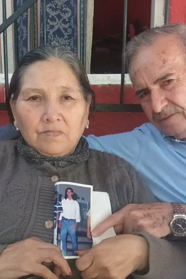 DOLOR. Los padres de Oscar Miguel sostienen una fotografía de su hijo.