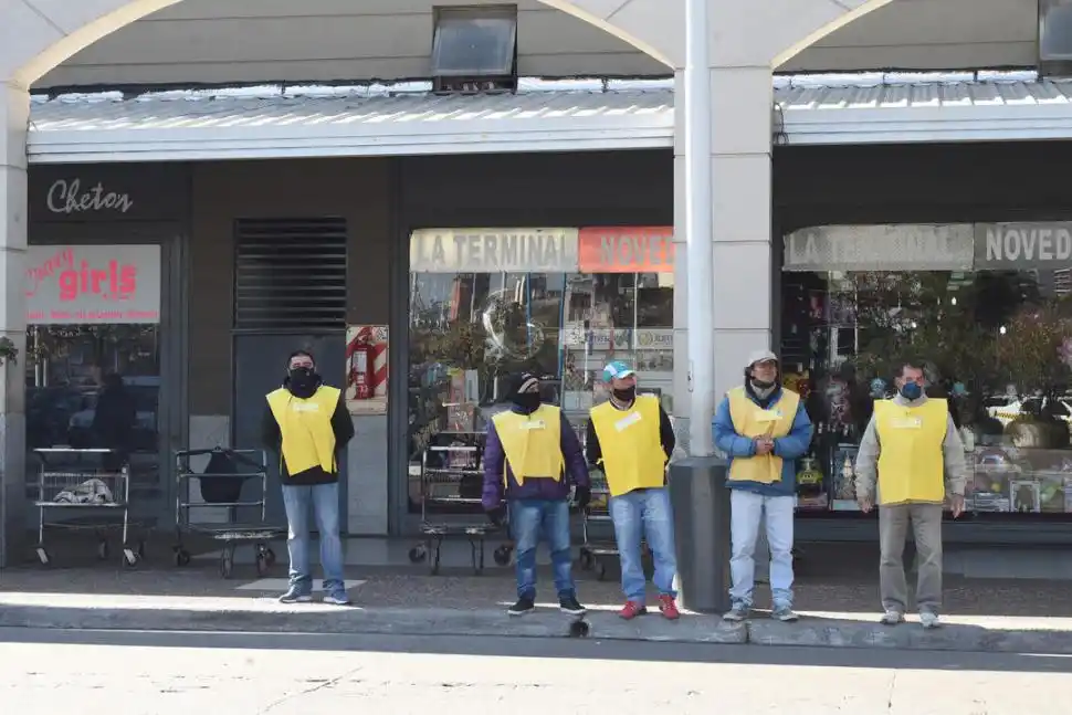 MALETEROS CON BARBIJO. Los trabajadores esperan la llegada de pasajeros. Esta será una temporada invernal con poco trabajo para ellos.