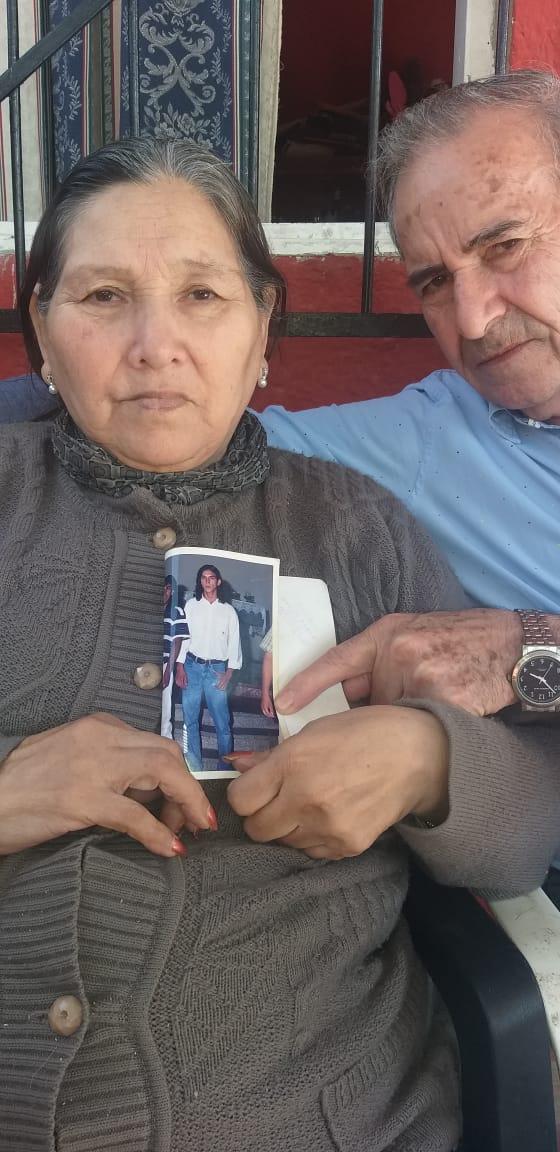 DOLOR. Los padres de Oscar Miguel sostienen una fotografía de su hijo.