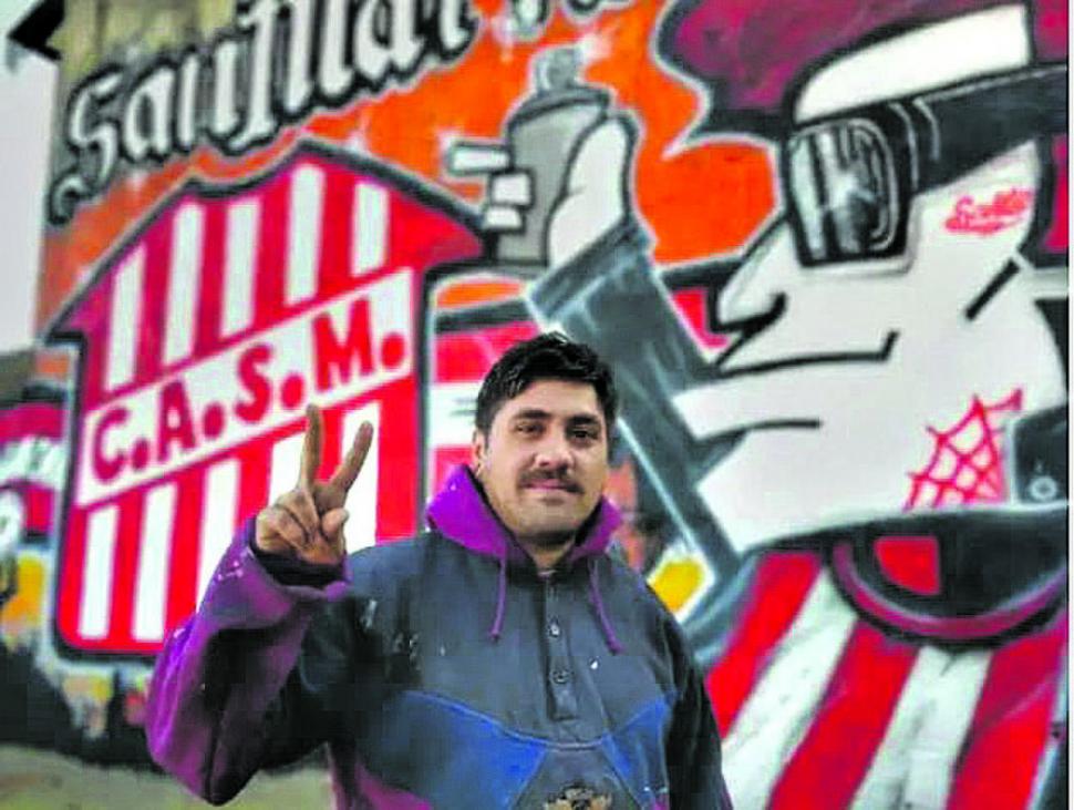 ORGULLOSO. “Luizito” posa con una de sus obras. El grafitero quiere pintar todo Tucumán con los colores de San Martín.  