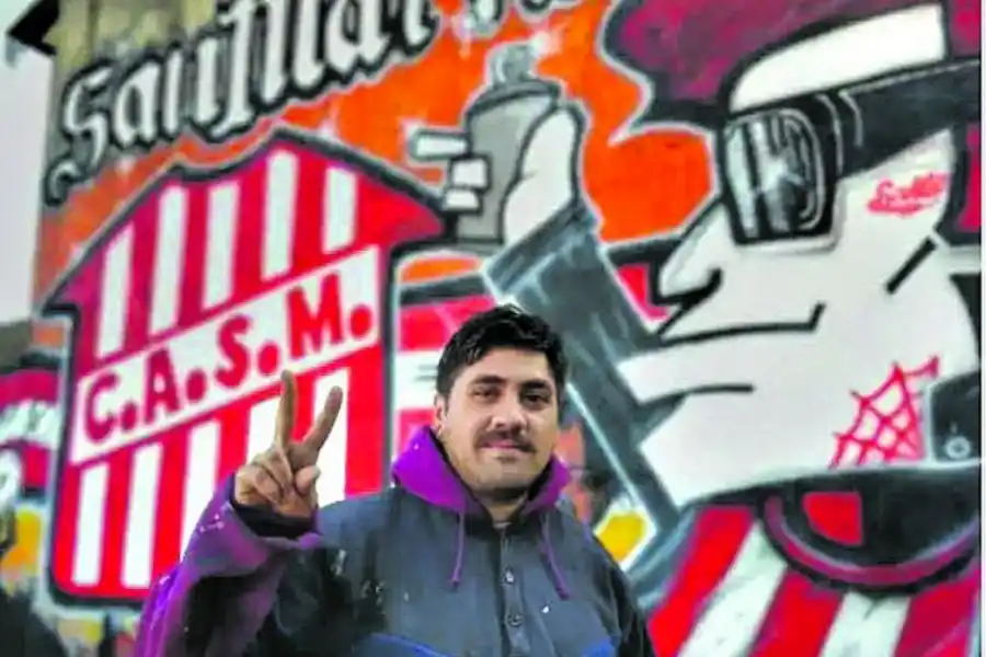 ORGULLOSO. “Luizito” posa con una de sus obras. El grafitero quiere pintar todo Tucumán con los colores de San Martín.  
