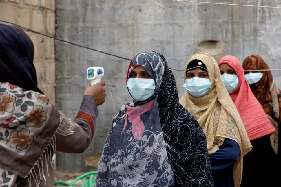 PAKISTÁN. Una enfermera le toma la temperatura a una mujer en Karachi.