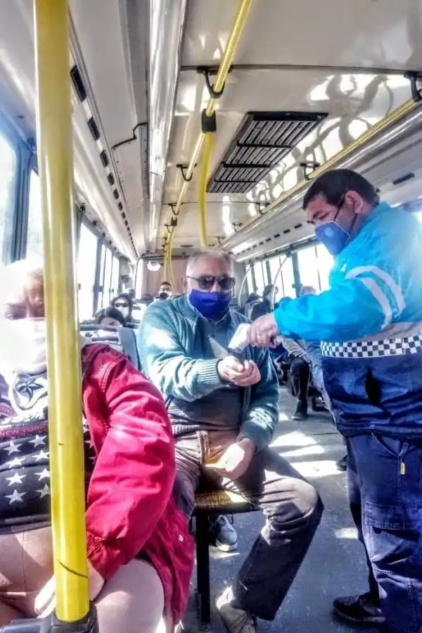 EN COLECTIVOS. Un empleado municipal le toma la temperatura a un pasajero. Foto: Municipalidad de YB