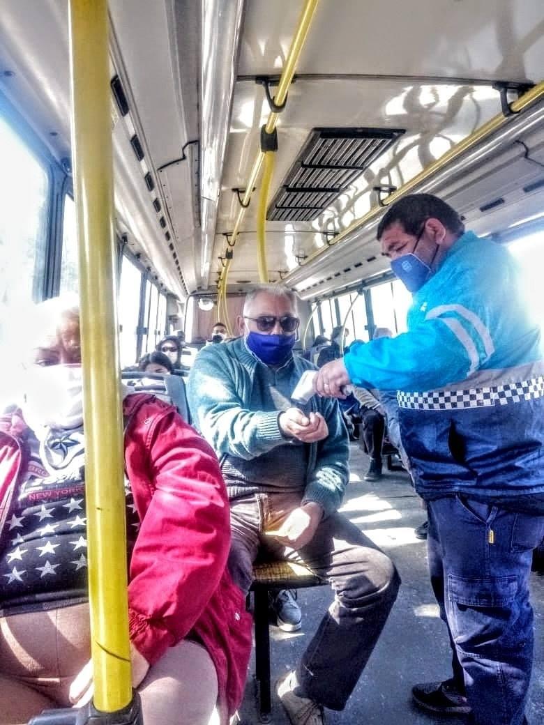 EN COLECTIVOS. Un empleado municipal le toma la temperatura a un pasajero. Foto: Municipalidad de YB