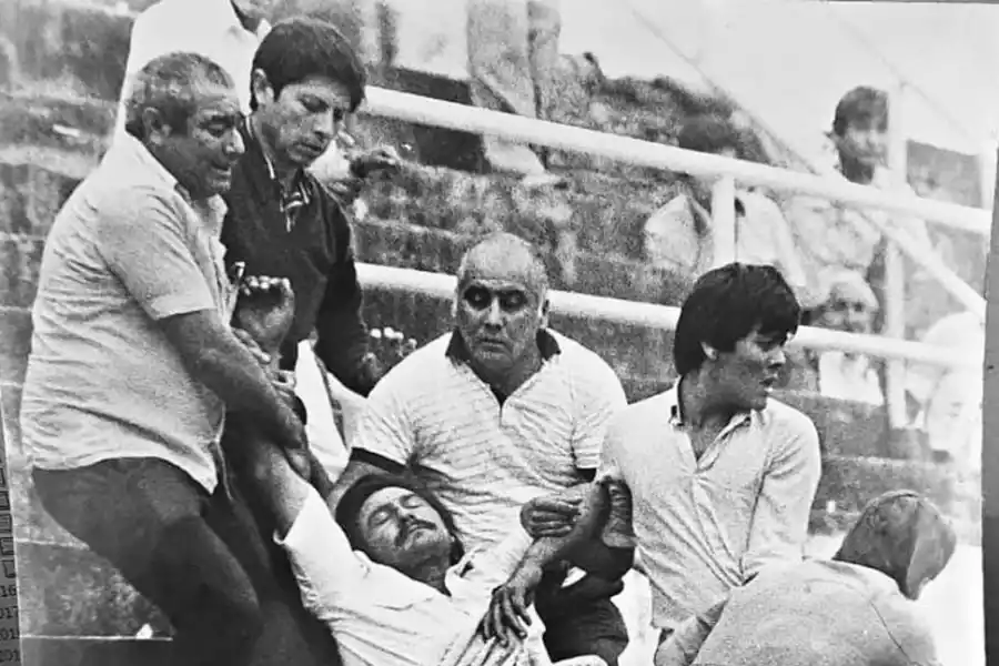 DRAMÁTICO. Cinco hinchas “decanos” trasladan a un hombre que había sufrido un desmayo en medio de la tribuna.