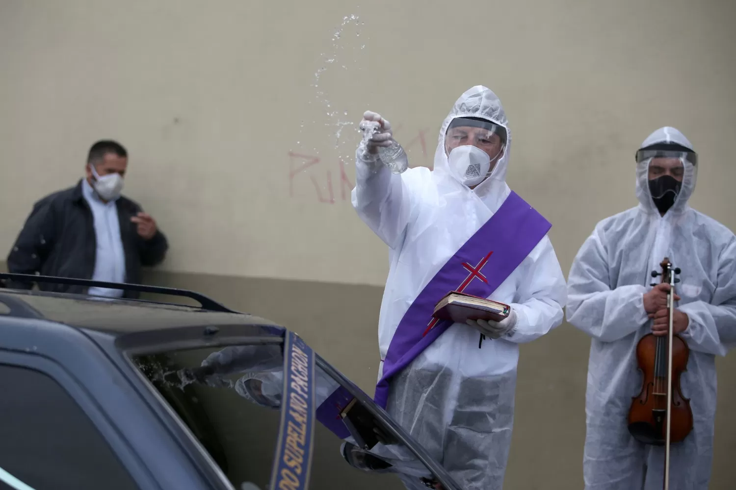 COLOMBIA. Un diácono se coloca un traje protector para despedir a los muertos por coronavirus.