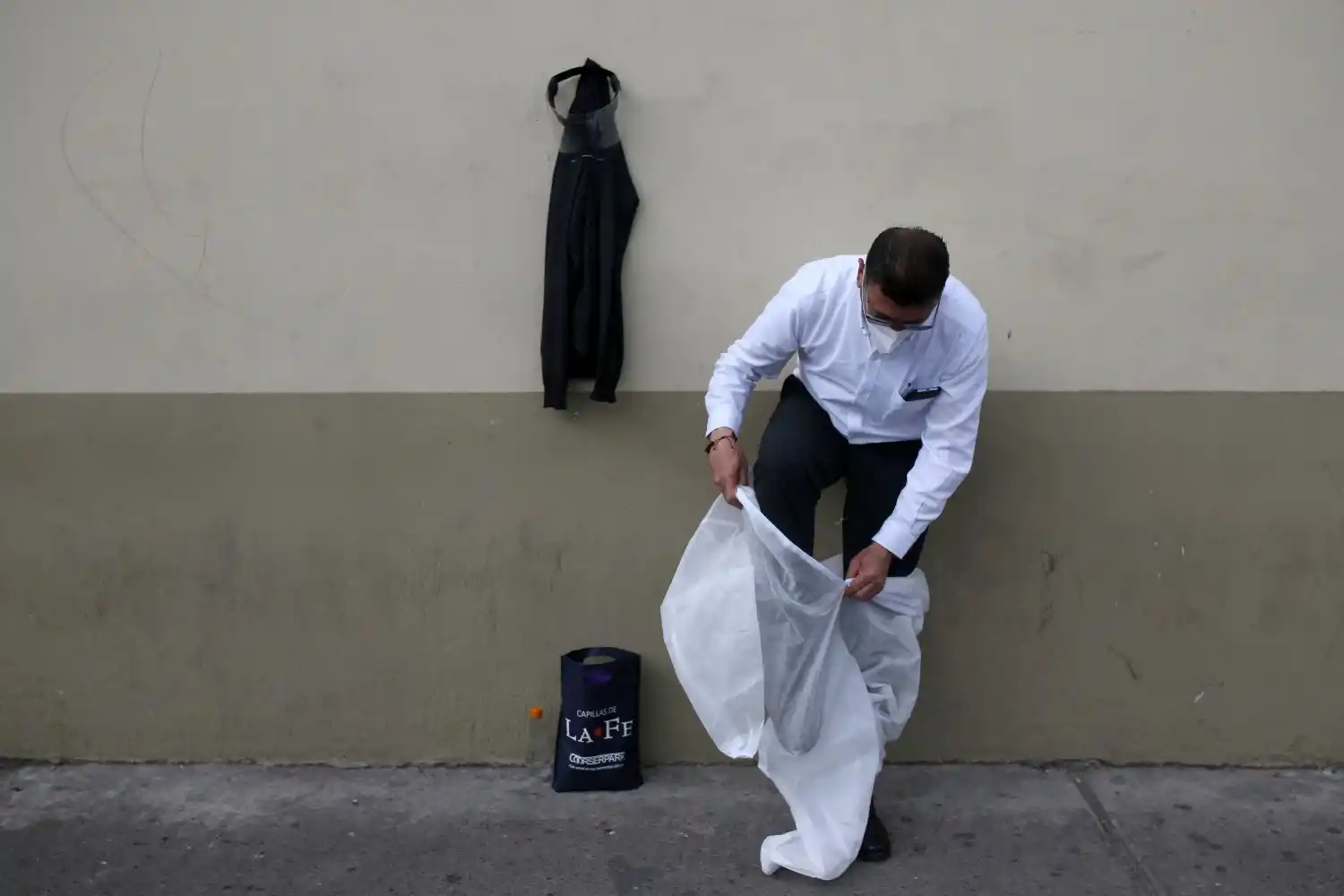 LA TRANSFORMACIÓN. Mauricio Castiblanco se pone un overol desechable, guantes de látex y se ajusta su máscara bajo un protector facial. 