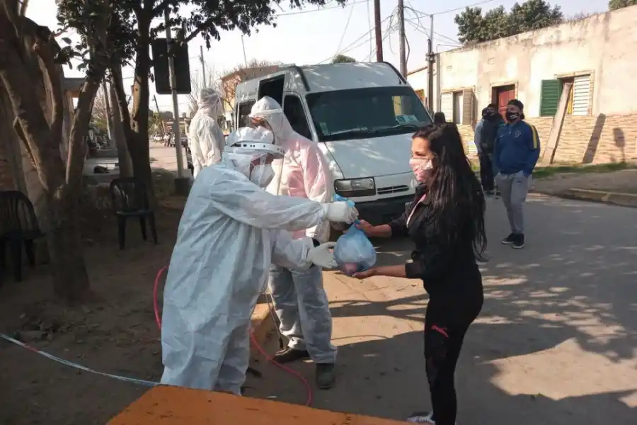 PROVISIONES. Un agente sanitario entrega suministros a una joven. 