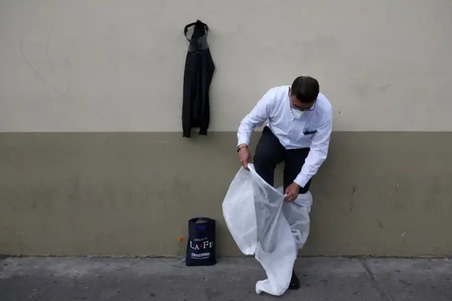 LA TRANSFORMACIÓN. Mauricio Castiblanco se pone un overol desechable, guantes de látex y se ajusta su máscara bajo un protector facial. 