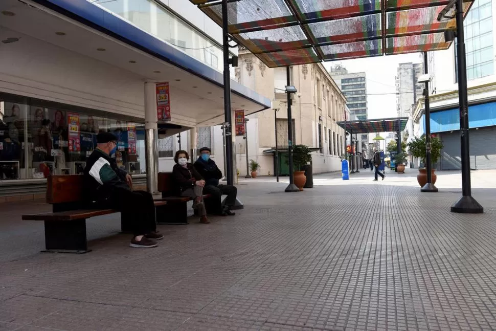 CHARLA A LA DISTANCIA. Jubilados conversan de un banco al banco. LA GACETA / Foto de José Nuno