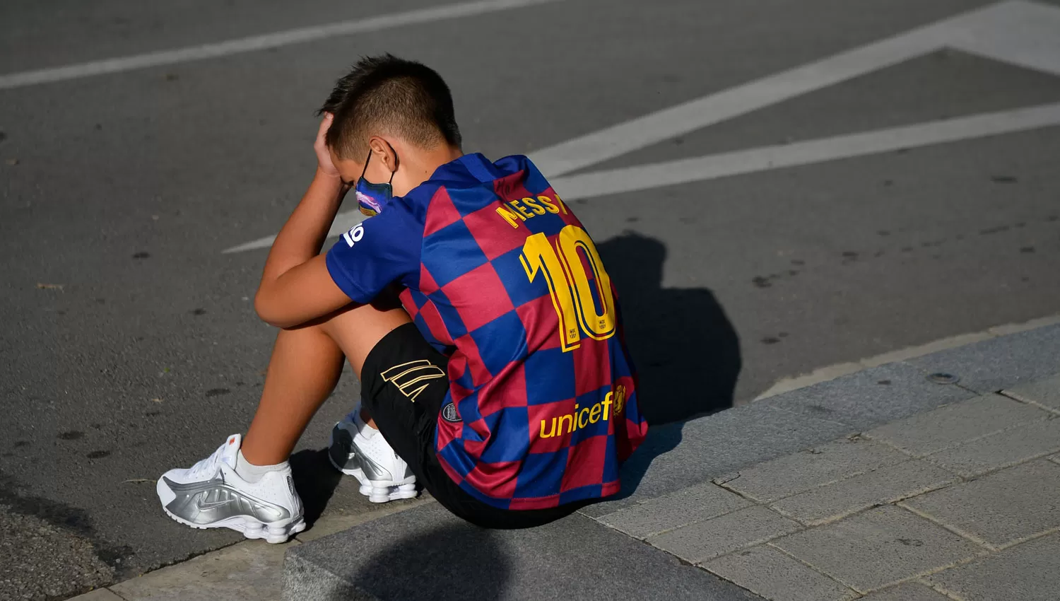 SIN CONSUELO. Un niño se toma la cabeza a la salida de la ciudad deportiva de Barcelona.
