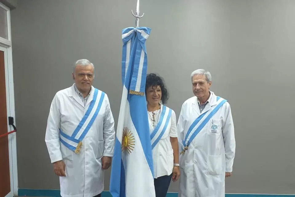 RECONOCIDOS. María Bellomio (abanderada), junto a los médicos Jesús Amenabar (a la izquierda) y Alfredo Casis. Foto: Facebook Hospital Centro de Salud