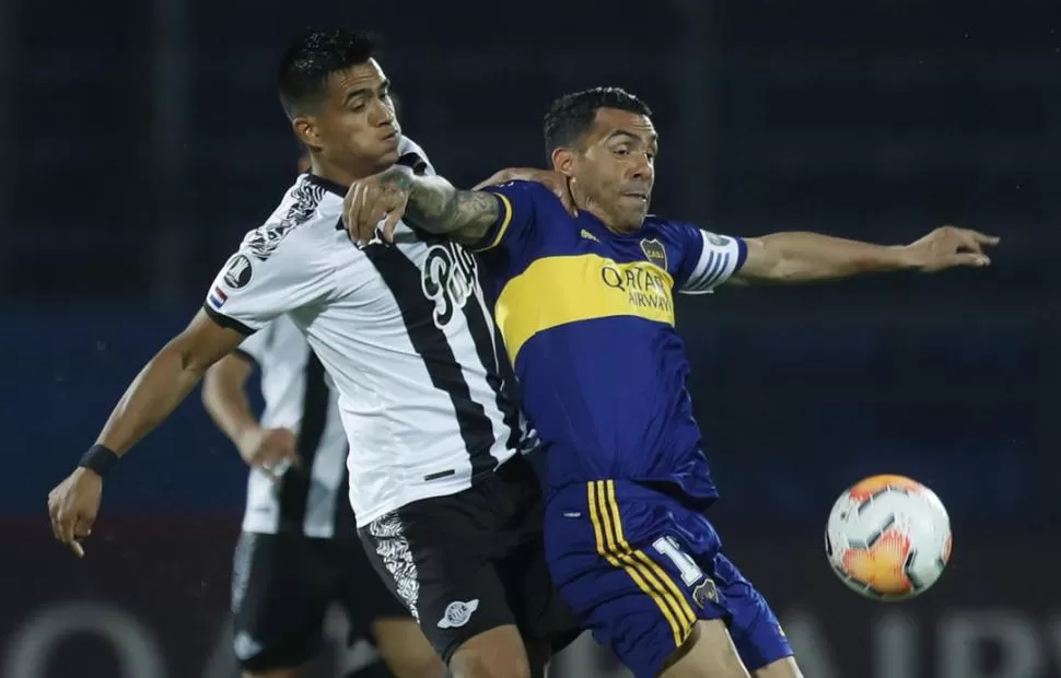 MUCHA LUCHA. Carlos Tevez aguante la marca de un jugador paraguayo. El “Apache” jugó un partido discreto en la noche de Asunción. telam