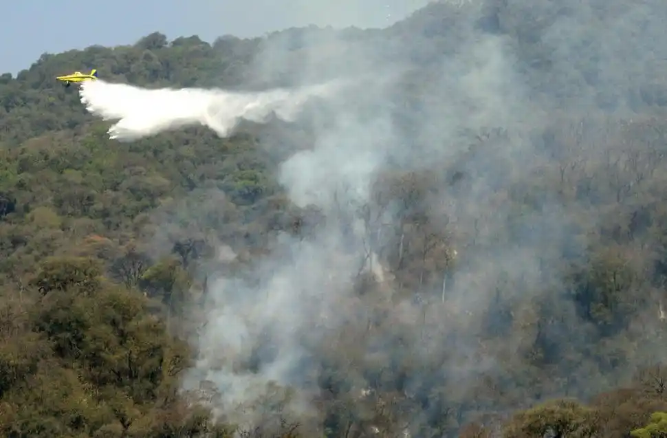 AYUDA AÉREA. Los aviones hidrantes dejaban caer una “lluvia” de 1.500 litros en el cerro.