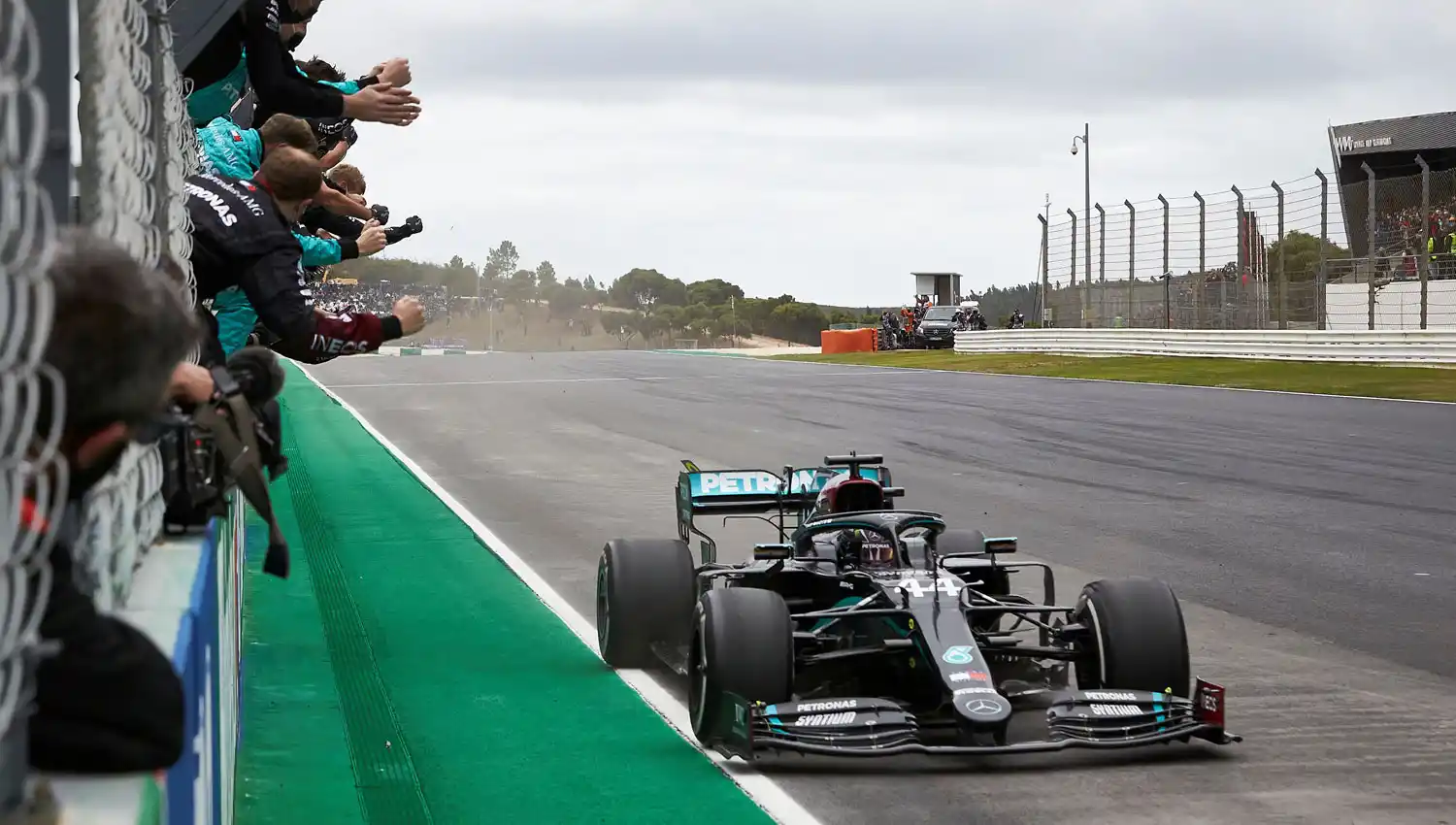 LA FOTO. Hamilton cruzó la meta junto al aliento de su equipo.