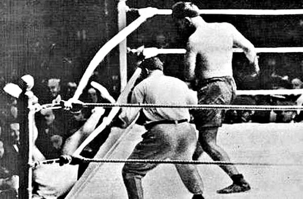 EN POLO GROUNDS. El argentino saca fuera del ring al campeón Jack Dempsey, quien trata de levantarse entre los periodistas apostados allí. 