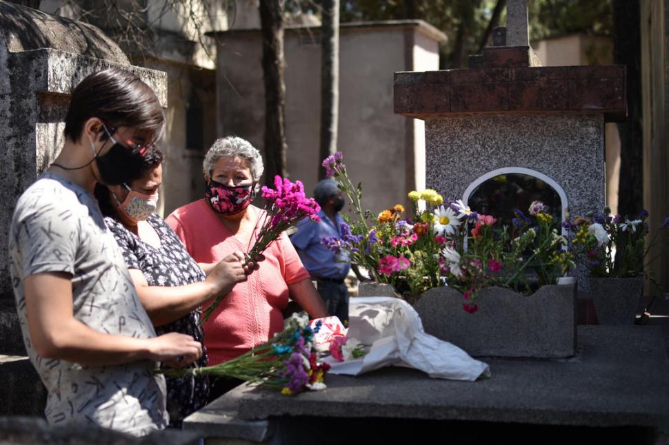 VISITA. Alicia Tejerina con su hija, Roxana Pérez, y con su nieto, Matías Pérez, colocando flores a sus difuntos. 