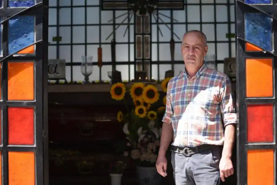 LUZ. Enrique Cuezzo en la puerta del mausoleo hecho con vidrios de color.